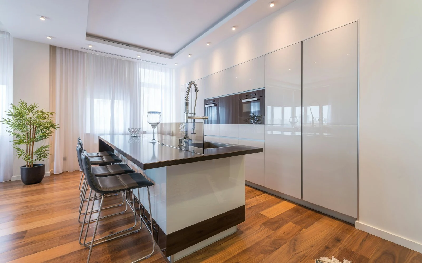 Cocina abierta con isla y suelo de aspecto madera en tono nogal